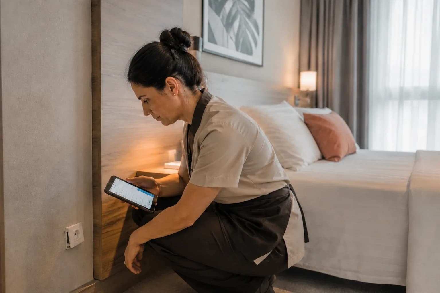 Room attendant logging a maintenance issue from a tablet with Avirato housekeeping