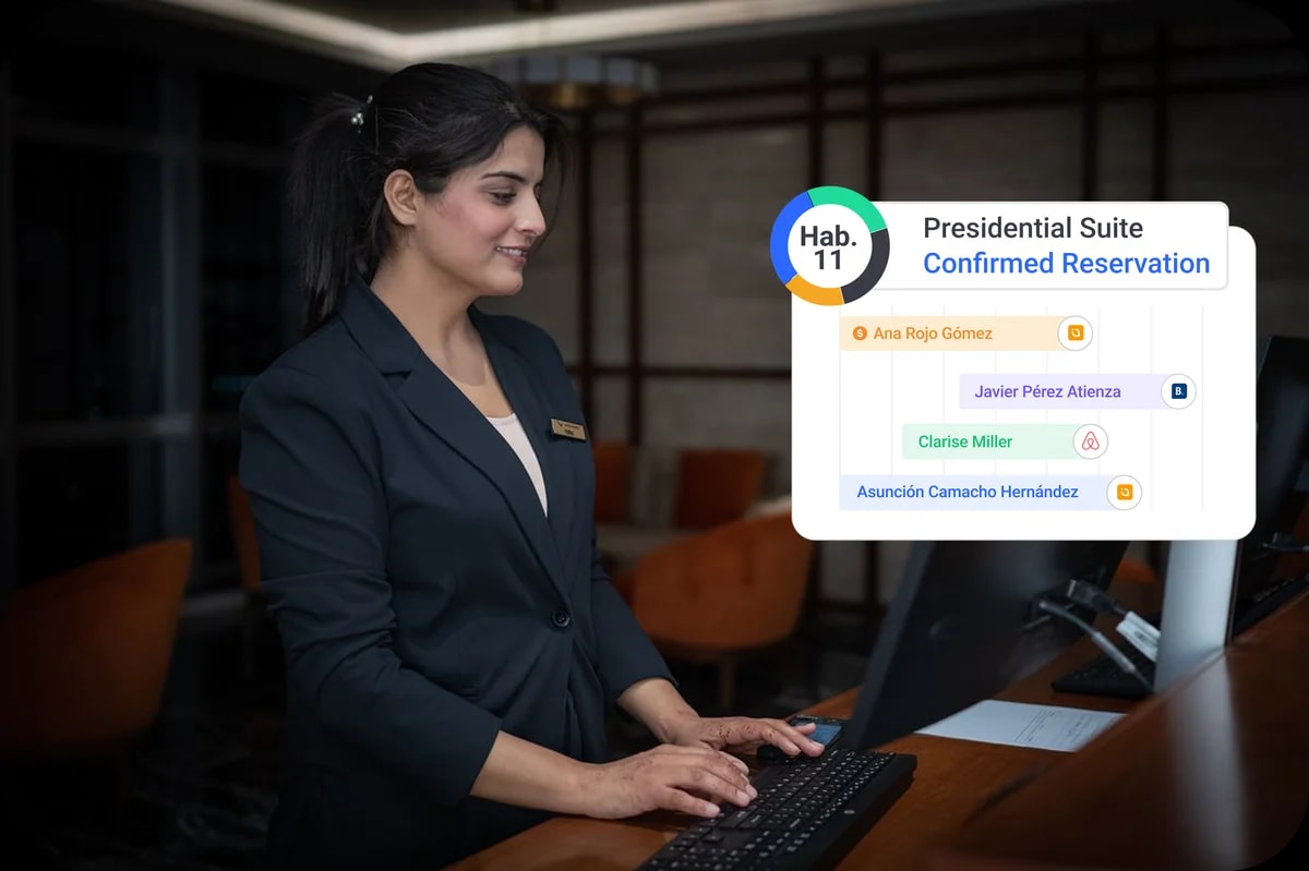 Recepcionista de hotel gestionando el planning de reservas del PMS Avirato, habitación 11, reserva confirmada y llegadas de Booking, Airbnb y web